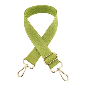 Detail of adjustable grass green woven bag strap with golden lobster clasps and diamond pattern
