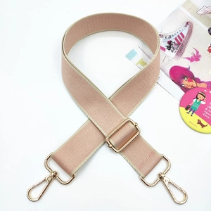 Close-up of dusty pink woven shoulder strap with gold metal hooks and adjustable buckle