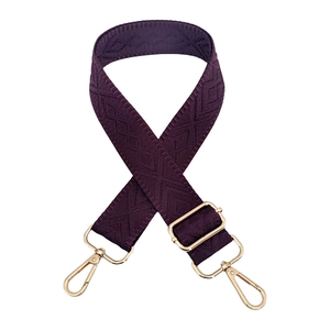 Detail of adjustable deep purple woven shoulder strap with gold geometric diamond pattern