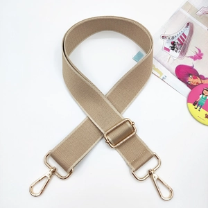 Detail of adjustable khaki canvas bag strap with polished gold-tone metal swivel hooks