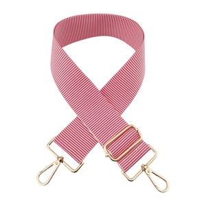 Detail of red and white striped 5cm wide bag strap with gold metal buckle and spring hooks