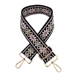 Close-up of ethnic geometric embroidered bag strap with gold metal lobster clasps