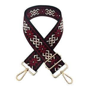 Close-up of ethnic style embroidered bag strap with geometric patterns and gold metal hardware