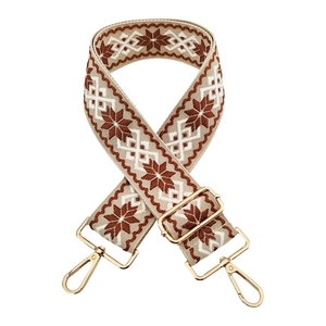 Detail of adjustable embroidered bag strap with ethnic geometric patterns and gold clips