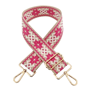 Detail of ethnic embroidery bag strap with geometric floral pattern and gold metal hooks