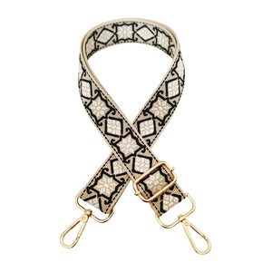Ethnic woven shoulder strap with black geometric pattern and gold metal hooks