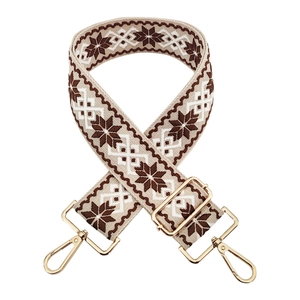 Detail of vintage geometric embroidery on adjustable strap with gold metal hooks