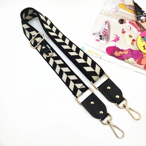 Adjustable woven shoulder strap with black-white chevron pattern and gold metal hooks