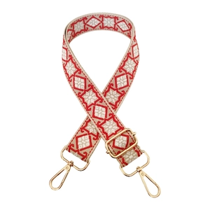 Close-up of geometric floral bag strap with gold metal buckles and adjustable hardware