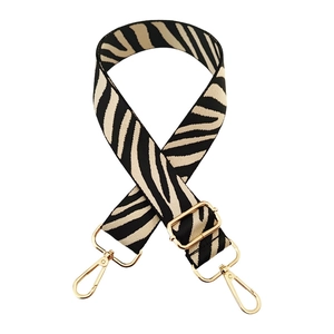 Adjustable black and white zebra pattern bag strap with polished gold hardware buckles