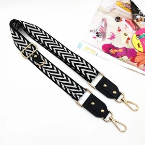 Detail of adjustable black and white herringbone strap with gold metal lobster clasps