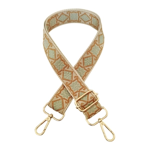 Detail of adjustable bohemian geometric pattern bag strap with gold metal buckles