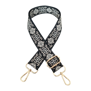Detail of black and white geometric ethnic pattern woven strap with gold lobster clasps
