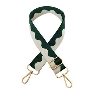 Detail of adjustable bag strap featuring green and white wave jacquard pattern with gold hooks