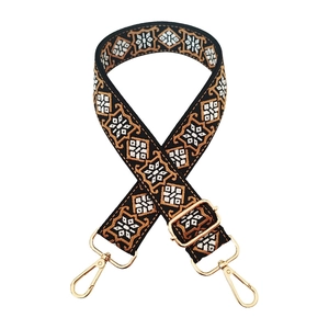 Detail of bohemian geometric embroidered bag strap with golden metal swivel hooks