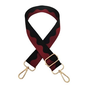 Detail of red and black wave pattern replacement bag strap with golden metal hooks