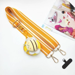 Detail view of yellow striped canvas bag strap with bee plush charm and metal hooks