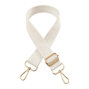 Detailed view of white woven shoulder strap with gold-tone metal clips and fishbone texture
