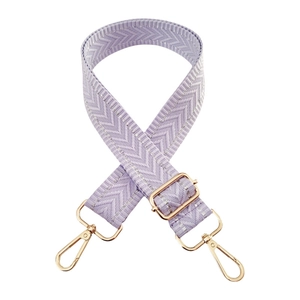 Detail of adjustable lavender woven bag strap with silver chevron pattern and gold metal hooks