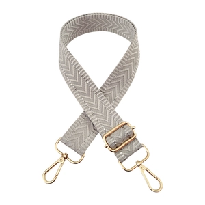 Detail of grey herringbone strap with silver thread and golden metal buckles