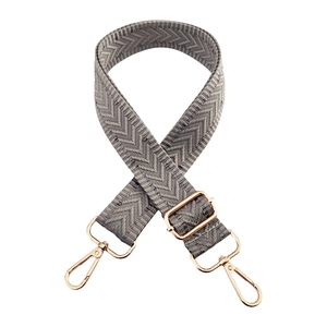 Detail of 3.8cm grey herringbone woven bag strap with polished gold metal hooks