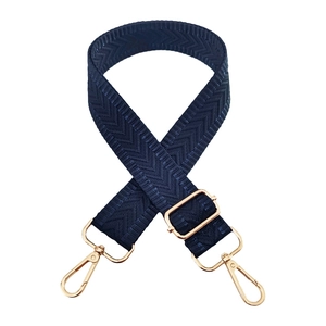 Macro detail of dark blue V-weave bag strap with golden metal lobster clasps and buckle