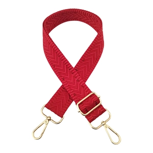 Detail of red chevron woven bag strap with adjustable gold-tone metal hardware