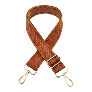 Close-up of caramel woven bag strap with V-shaped texture and gold metal hardware