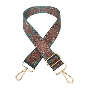 Detail of turquoise and brick red ethnic pattern woven strap with gold metal buckles