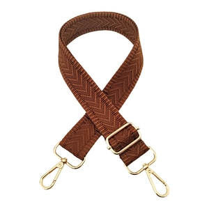 Macro view of brown chevron weave shoulder strap with polished gold-tone metal hardware