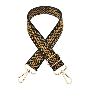 Detail of adjustable woven bag strap with geometric wave pattern and gold metal hooks