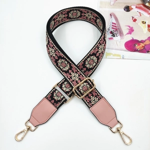 Detail of colorful jacquard woven strap with golden lobster clasps and pink leather trim