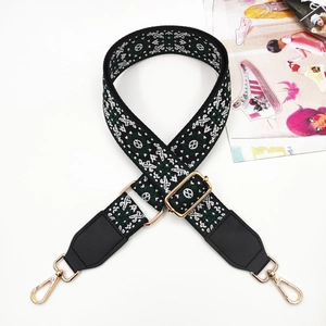 Detail of colorful ethnic pattern bag strap with gold metal hooks and black leather trim