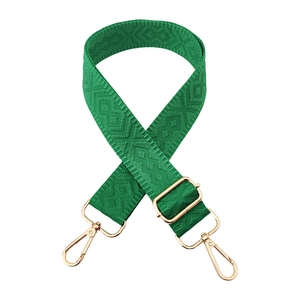 Close-up of green diamond weave bag strap with luxury gold hardware and adjustable buckle