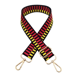 Detail of red, yellow, and black geometric woven wide strap with gold metal hooks