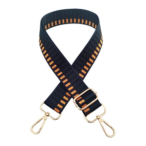 Detailed view of striped crossbody strap with premium gold lobster clasps and buckles