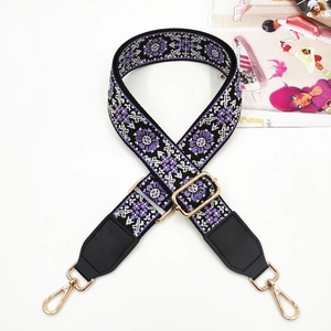 Close-up of ethnic embroidered guitar bag strap with purple patterns and golden hooks