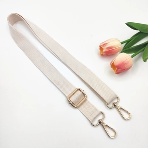 Detail of ivory cotton adjustable shoulder strap with premium gold metal buckles