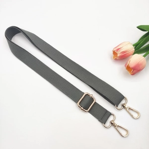 Detail of dark grey adjustable canvas strap with gold metal hooks and pink tulips
