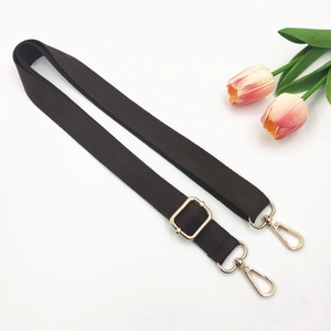 Detailed view of adjustable dark brown cotton shoulder strap with gold metal hardware