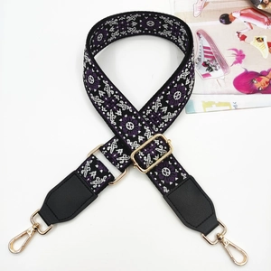 Close-up of ethnic geometric jacquard guitar strap with gold hooks and black leather ends
