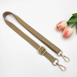 Close-up of adjustable khaki cotton strap with golden metal buckles and lobster clasps