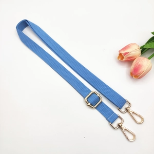 Close-up of sky blue adjustable cotton bag strap with polished gold metal hardware
