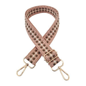 Detail of colorful woven shoulder strap with gold metal buckle and lobster clasp hardware
