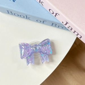 Close-up of purple bow phone socket with shimmering heart-shaped sequins and glitter
