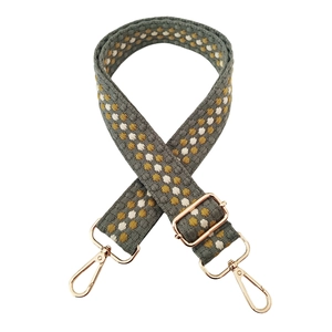 Close-up of thick grey woven strap with yellow polka dots and gold swivel hooks