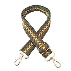 Detail of adjustable geometric woven shoulder strap with gold metal lobster clasps