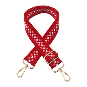 Detail of red woven bag strap with pink embroidery and gold-tone metal hooks