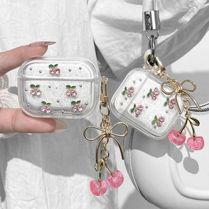 Sparkly clear cherry AirPods case with pink rhinestones and a gold bow keychain accessory