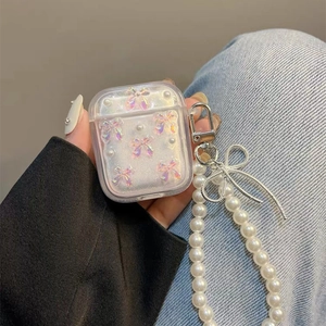Glitter AirPods case with iridescent bow, pearl chain and silver bow charm accessory
